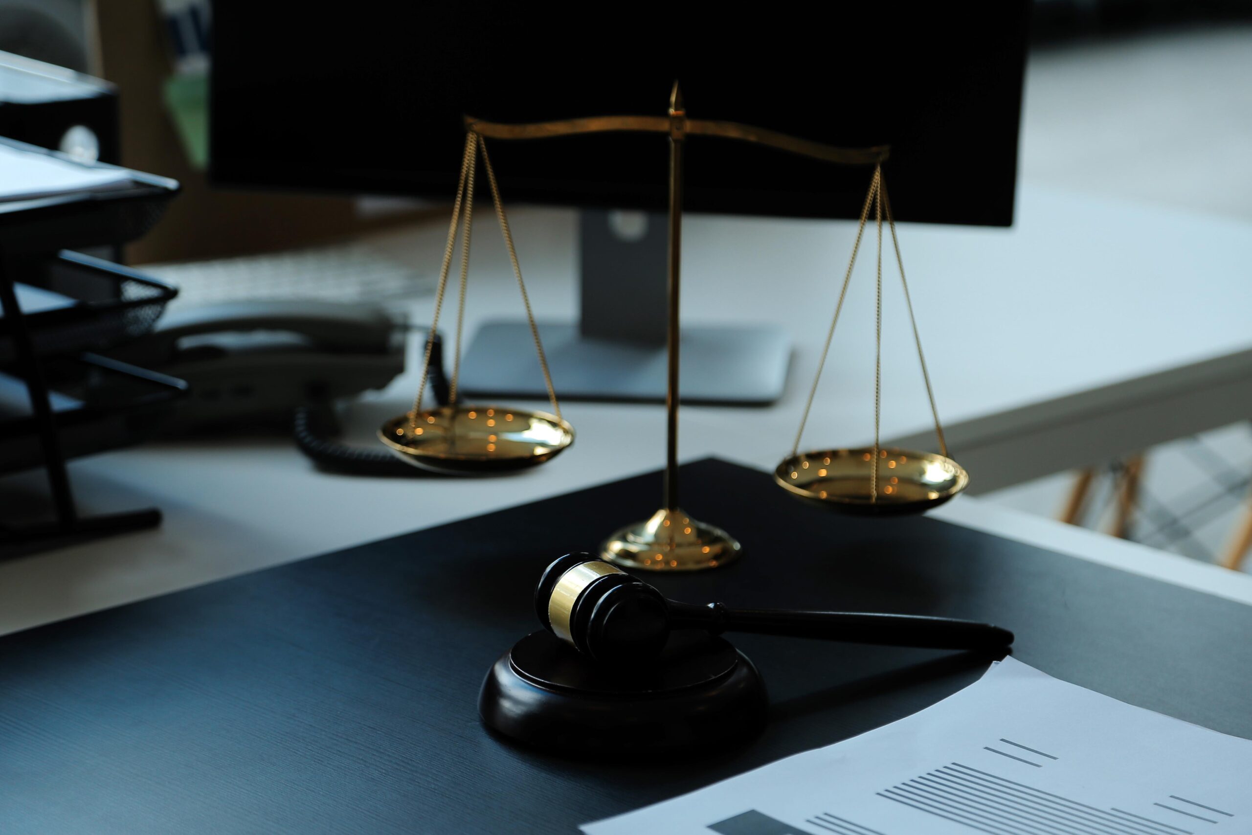 Despacho de abogados con mazo, balanza e informes