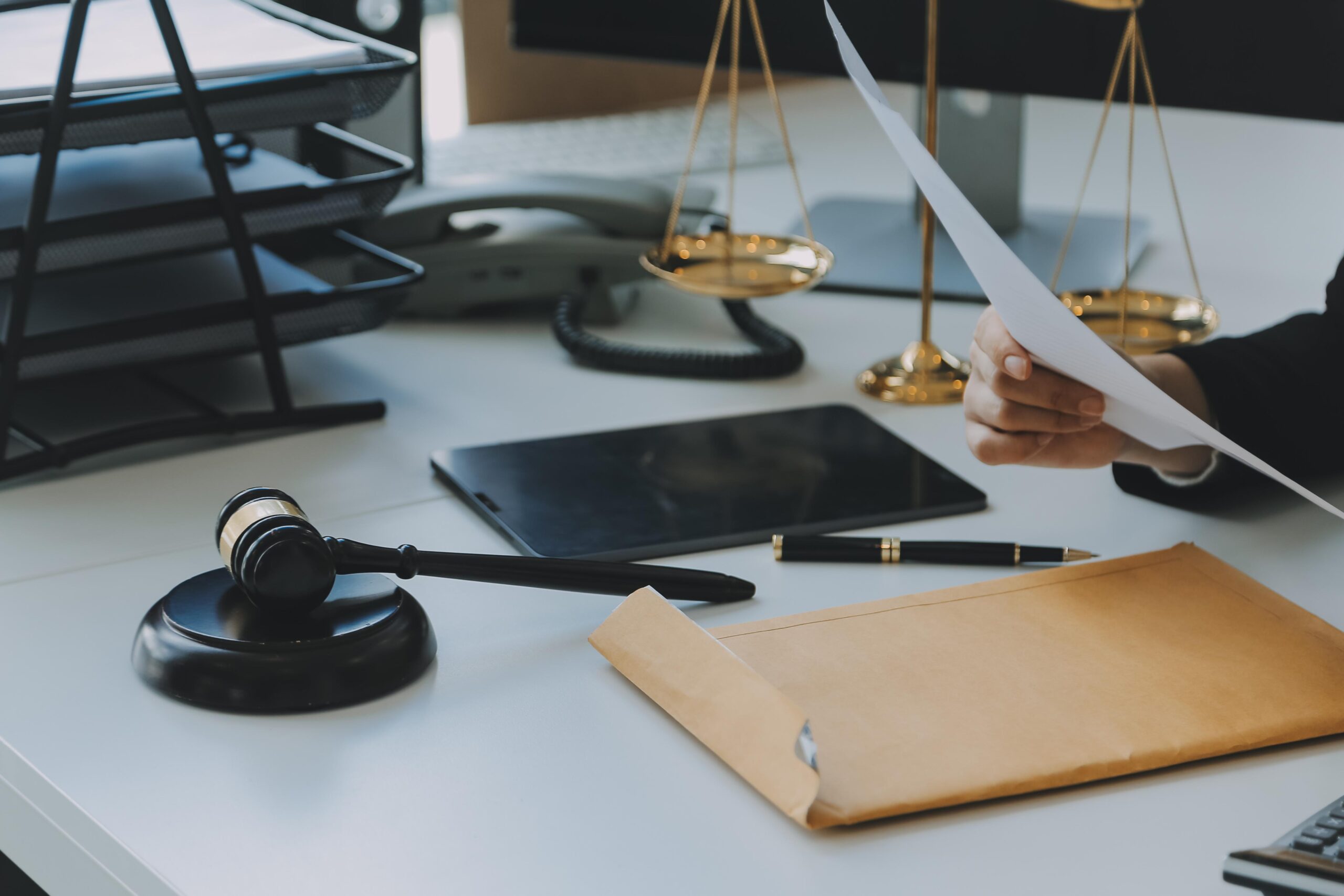 Despacho de abogados con mazo, balanza e informes